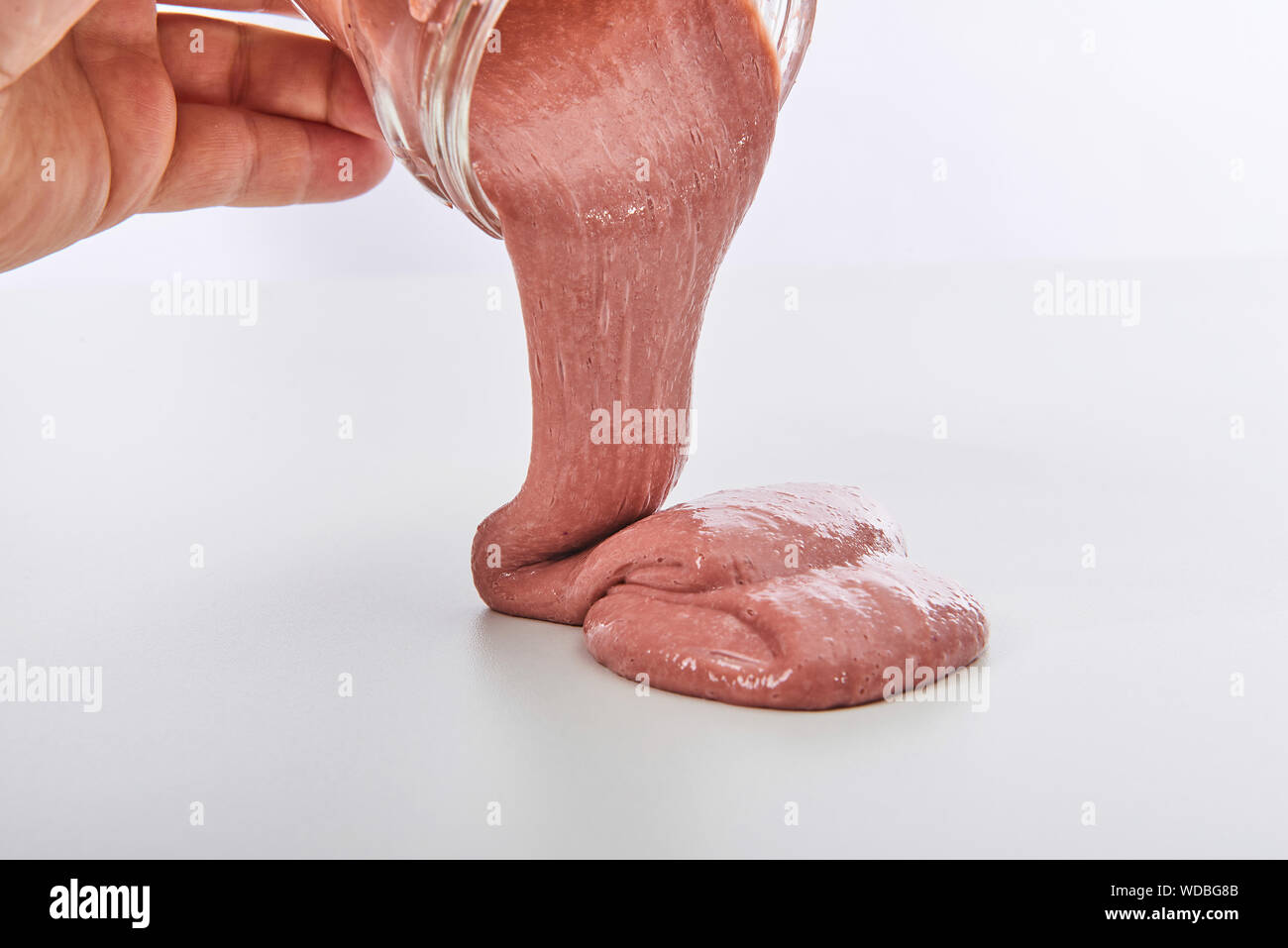 Toy chiamato Slime fuoriuscita dal vaso su sfondo bianco Foto Stock
