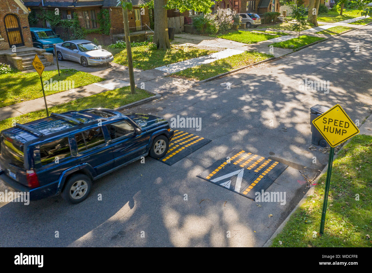 Detroit, Michigan - Una vettura attraversa un 'speed gobba" in un quartiere residenziale. La città ha iniziato l'installazione di tali dispositivi su strade dove accelerando Foto Stock
