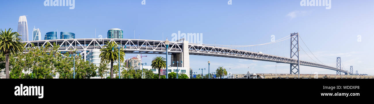 Vista panoramica del Bay Bridge spanning dal quartiere finanziario per l'isola del tesoro su un soleggiato e giorno chiaro, San Francisco, California Foto Stock
