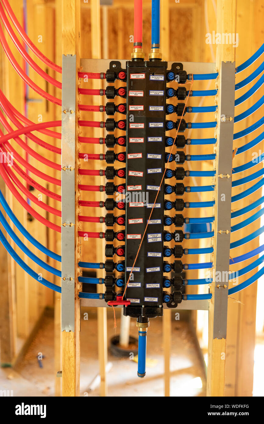 PEX plumbing il collettore di distribuzione di acqua nella nuova casa costruzione Foto Stock
