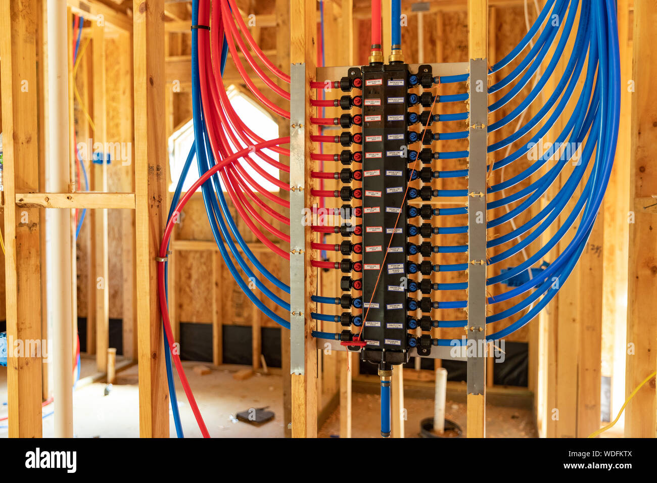 PEX plumbing il collettore di distribuzione di acqua nella nuova casa costruzione Foto Stock