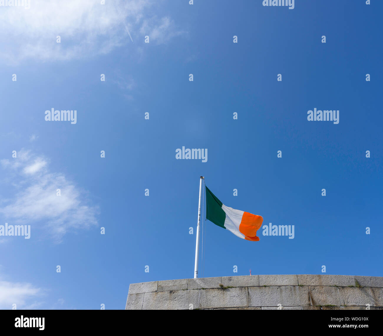 La bandiera tricolore della Repubblica Irlandese in volo da un edificio a Dun Laoghaire. Foto Stock