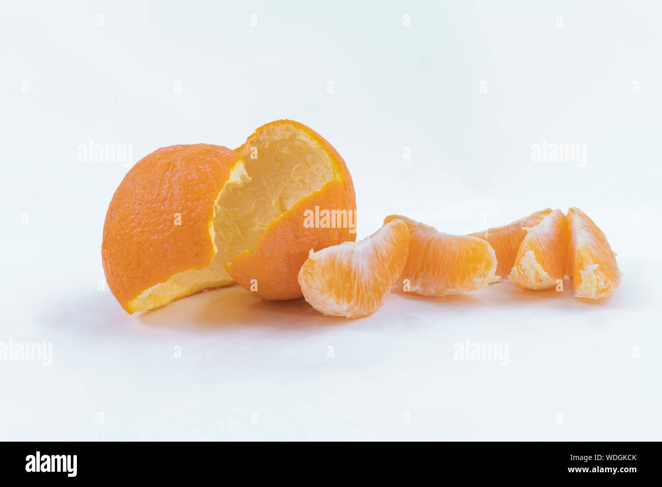 Buccia di arancia e le fette su uno sfondo bianco - arancio dolce snack Foto Stock