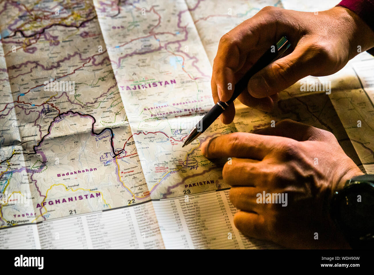Una mano segna la regione di confine tra Tagikistan, Afghanistan e Pakistan con una penna a sfera su una mappa stradale a Pish, Tagikistan. Foto Stock