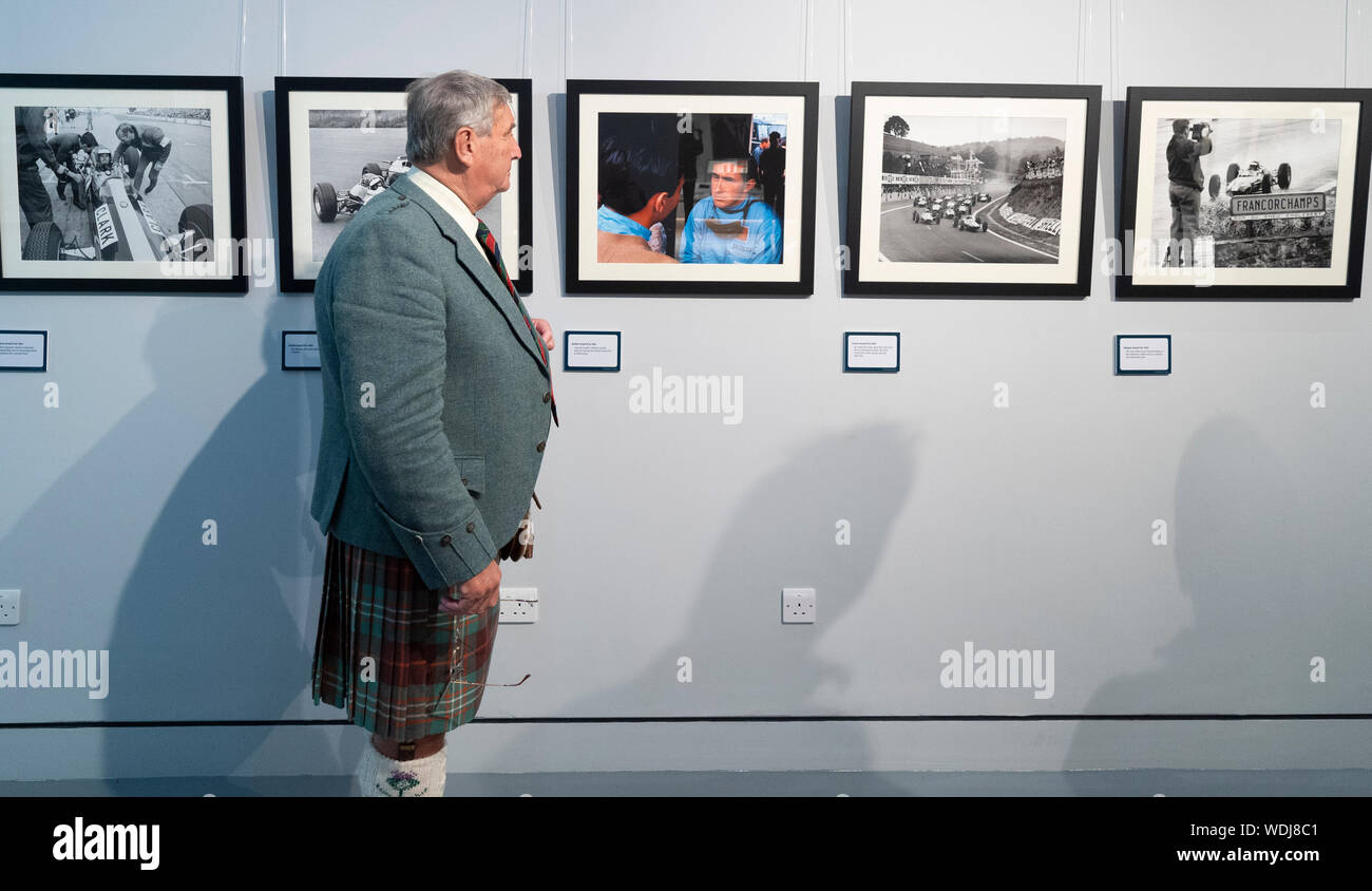 Duns, Scotland, Regno Unito. Il 29 agosto, 2019. Apertura ufficiale del nuovo Jim Clark Motorsport Museum a Duns, Berwickshire, UK. Il museo è stato inaugurato da Sir Jackie Stewart e viene azionato ma Jim Clark fiducia. Nella foto, Visitatore guardando fotografie vintage sul display. Credito: Iain Masterton/Alamy Live News Foto Stock