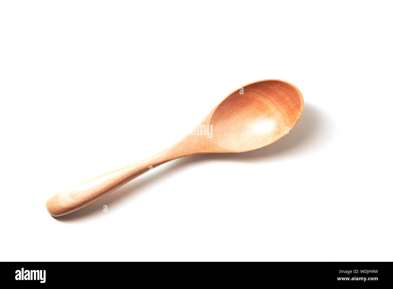 Close-up di un cucchiaio di legno contro uno sfondo bianco Foto Stock