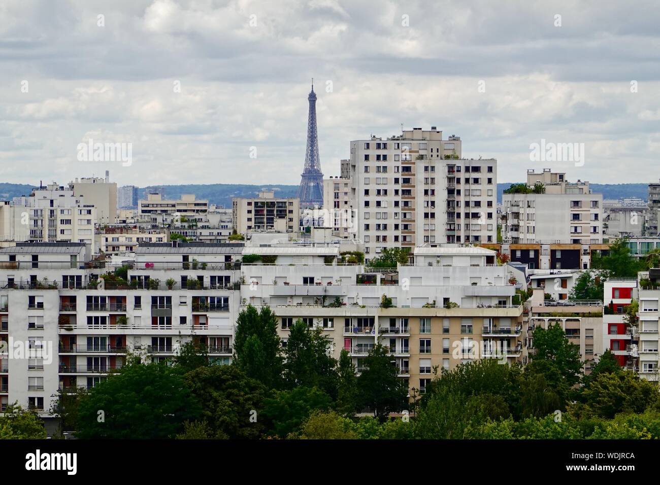 Torre Eiffel come si vede attraverso le sommità di edifici di appartamenti a partire dal diciannovesimo arrondissement di Parigi, Francia Foto Stock