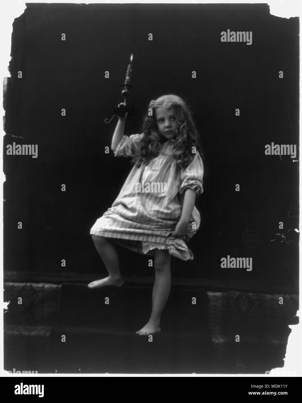 Ragazza in azienda nightgown candela su passi Abstract/medio: 1 stampa fotografica. Foto Stock