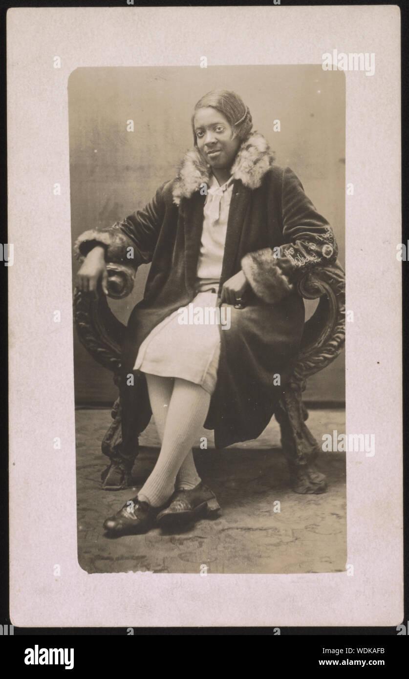 Gladys Dowdell, indossare pellicce cappotto Collard, a piena lunghezza ritratto in studio, seduto, rivolto verso la parte anteriore Abstract/medio: 1 fotografia : B&W Stampa foglio 14 x 9 cm (formato cartolina) Foto Stock