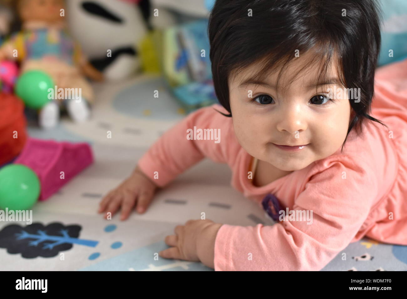 Sorridente bambina di imparare a strisciare in vivaio Foto Stock