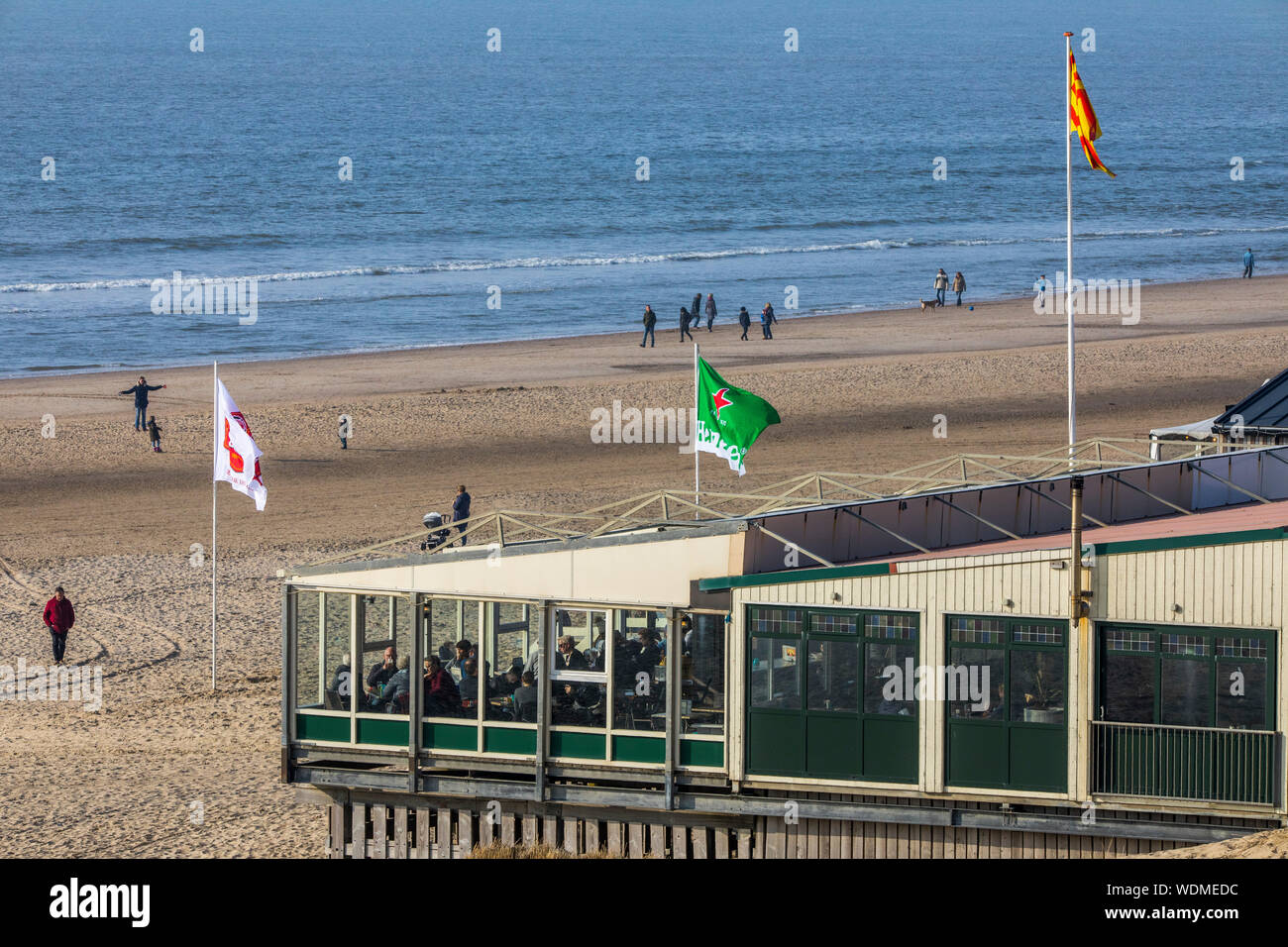 Walkers sulla spiaggia del Mare del Nord di Egmond aan Zee, North Holland, Paesi Bassi, spiaggia di bancarelle, ristoranti, caffè, Foto Stock