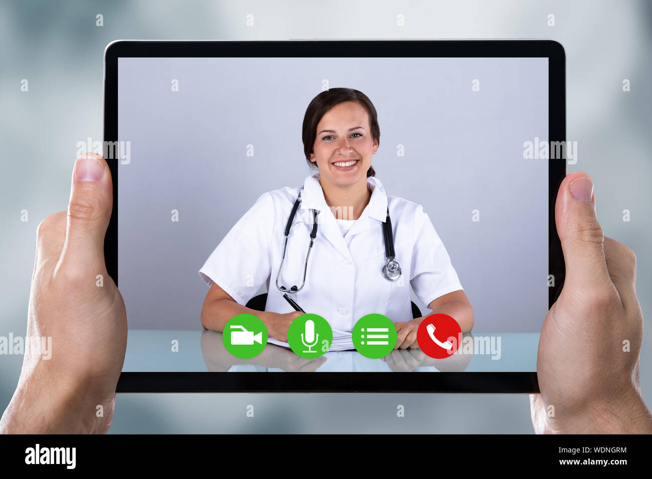 Close-up di una persona a fare video conferenza con il medico su tavoletta digitale Foto Stock
