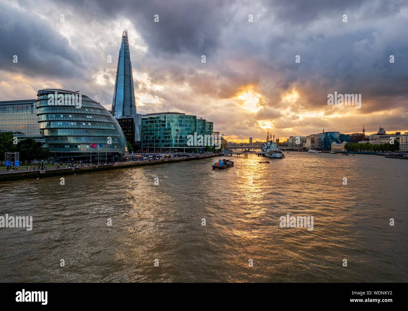 Il fiume Tamigi illuminato dal tramonto con i famosi punti di riferimento lungo la riva del fiume a Londra in Inghilterra Foto Stock
