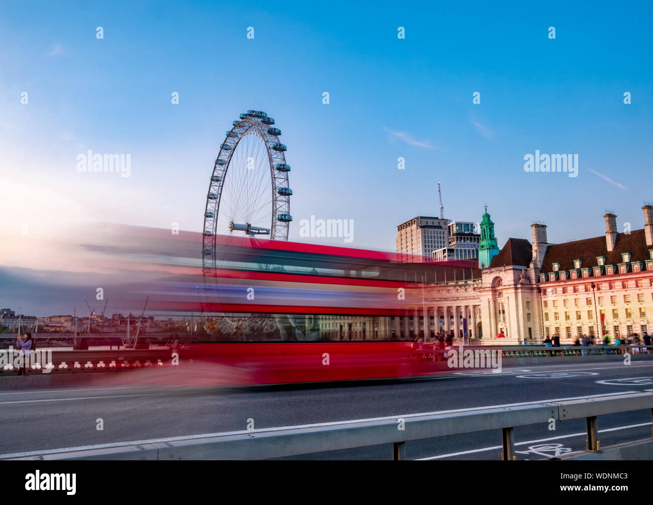 Fotografie con lunghi tempi di esposizione di double decker bus rosso in movimento su Abbazia di Westminster Bridge contro l'Occhio di Londra in Inghilterra Foto Stock