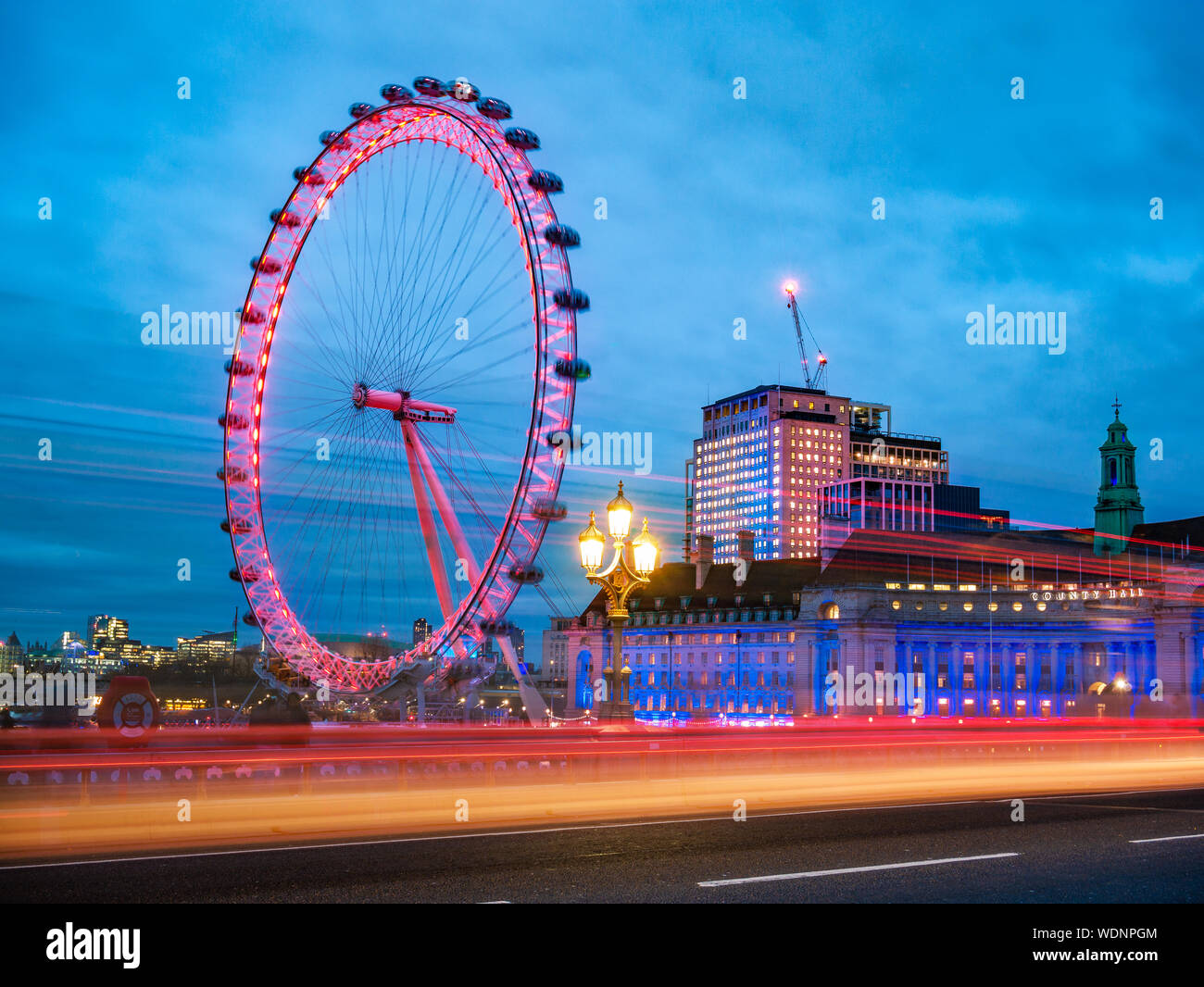 Vista del famoso London Eye dall'Abbazia di Westminster Bridge con auto rossa tracce nella composizione - Inghilterra, Regno Unito Foto Stock