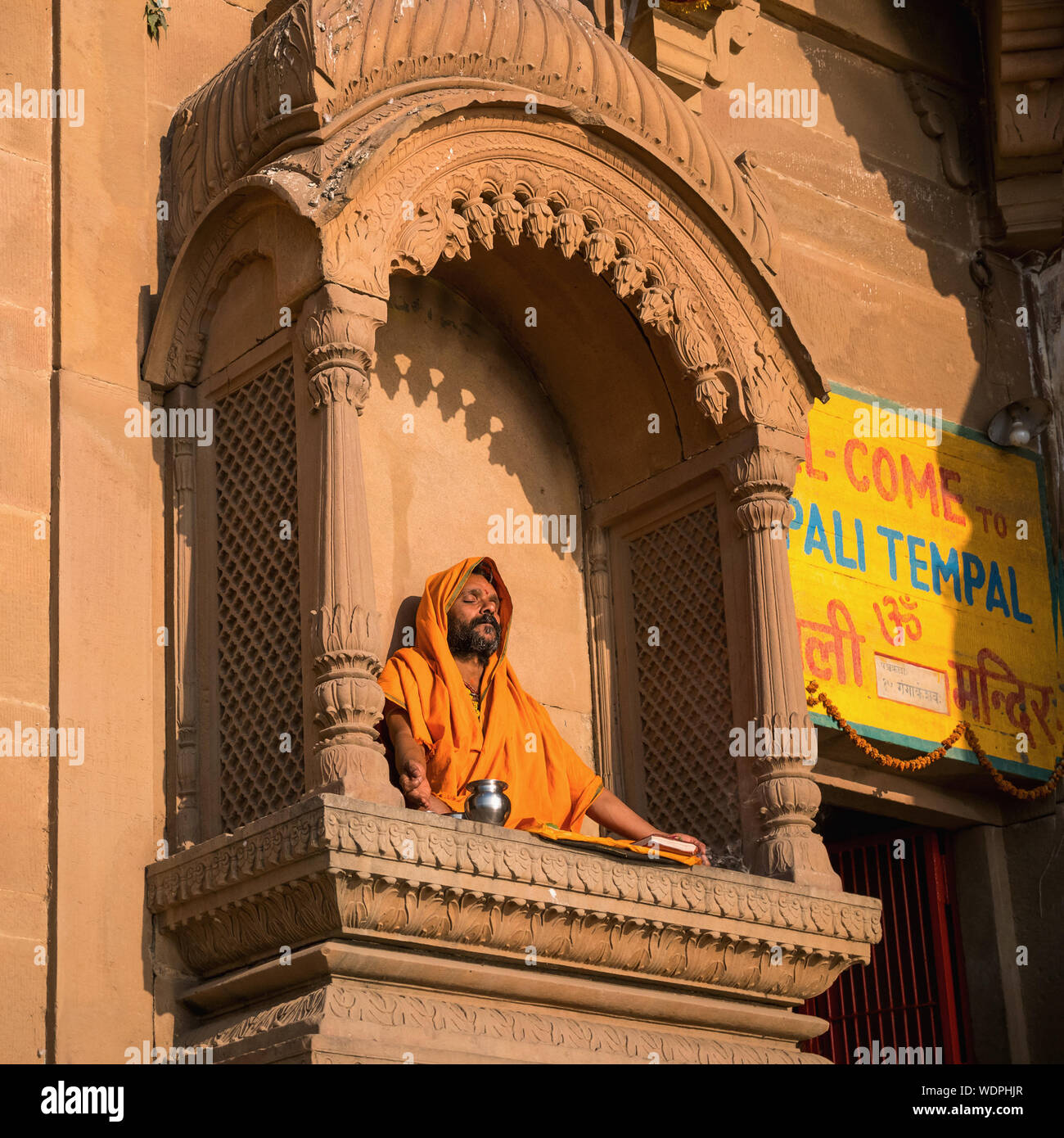 Sadhu Uomo Santo meditando sul tempio della davanzale, Varanasi, Uttar Pradesh, India, Asia Foto Stock