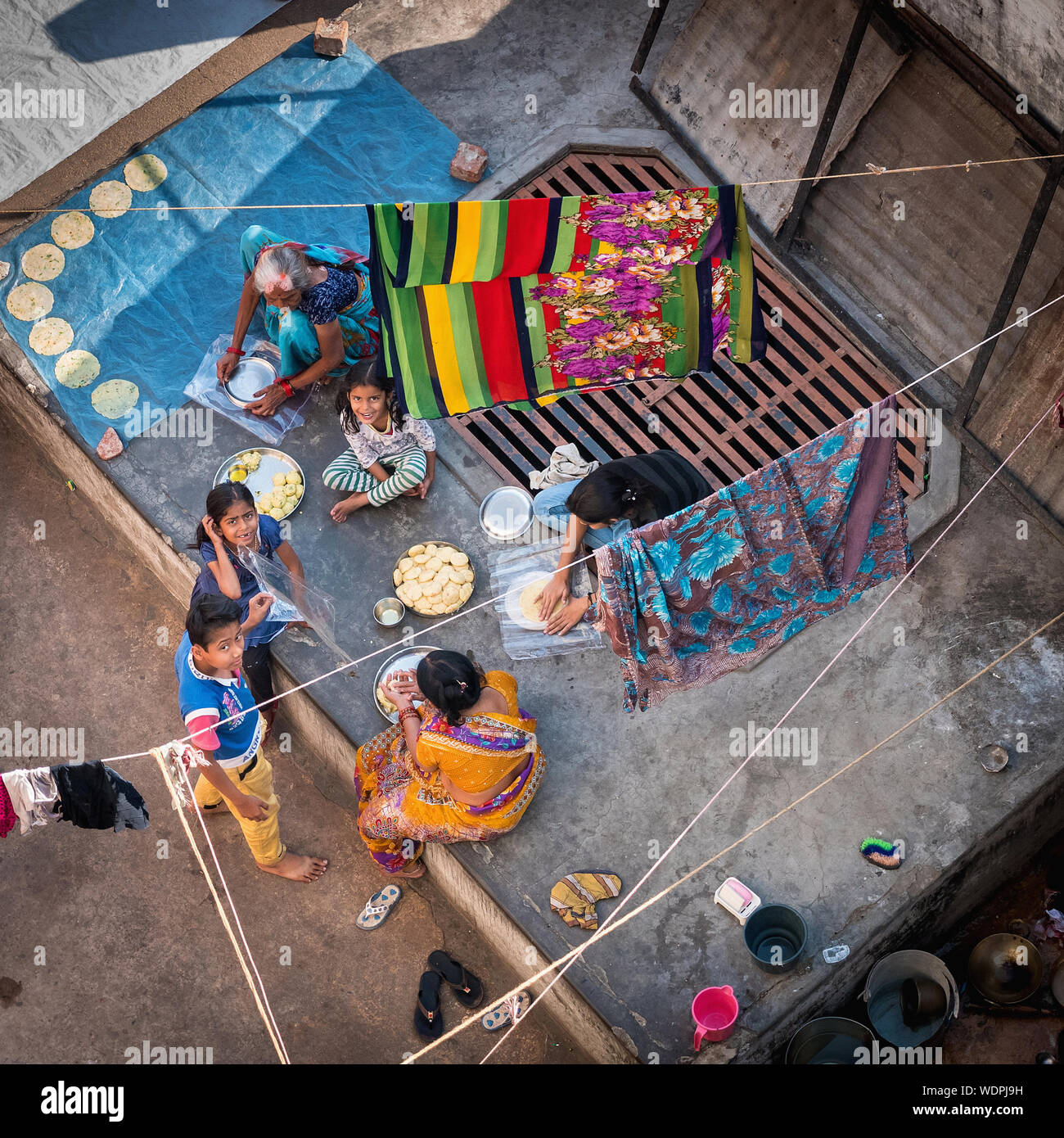 Famiglia indiana rendendo chapati flatbread sulla loro patio panoramico di Varanasi, Uttar Pradesh, India, Asia Foto Stock