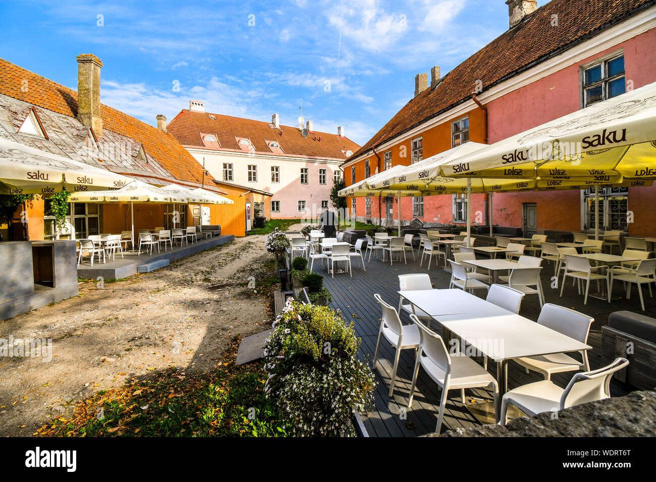 Un lavoratore di servizio predispone un cafe' all'aperto per i clienti nella zona medioevale della collina di Toompea, parte della Città Vecchia di Tallinn, Estonia. Foto Stock