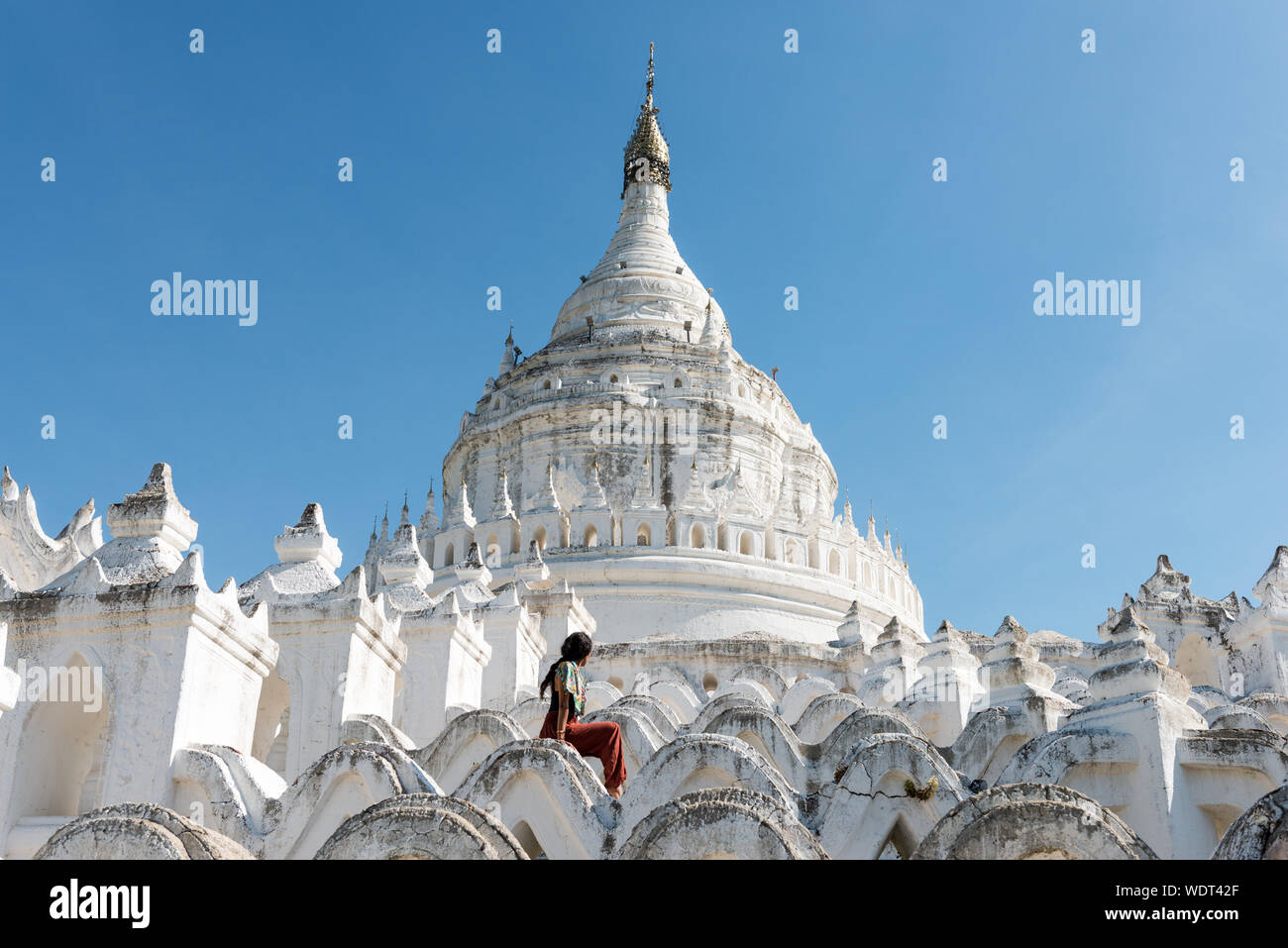 Ampio angolo di immagine del giovane turista a Pagoda Hsinbyume, un famoso tempio buddista dipinto in bianco, punto di riferimento del Myanmar, situato vicino a Mandalay Foto Stock