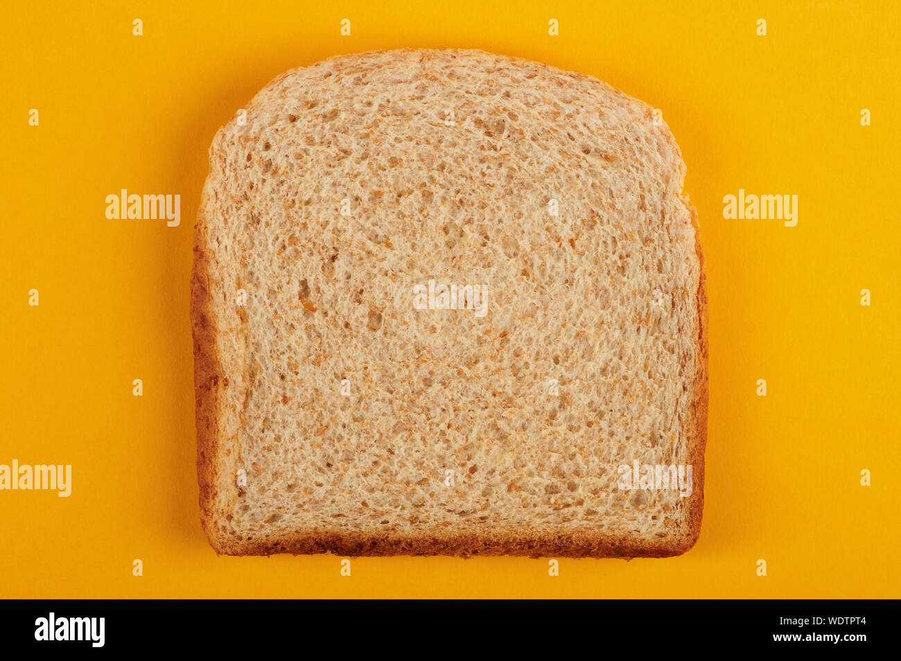 Uno bianco fetta di pane sopra vista dall'alto su sfondo giallo Foto Stock