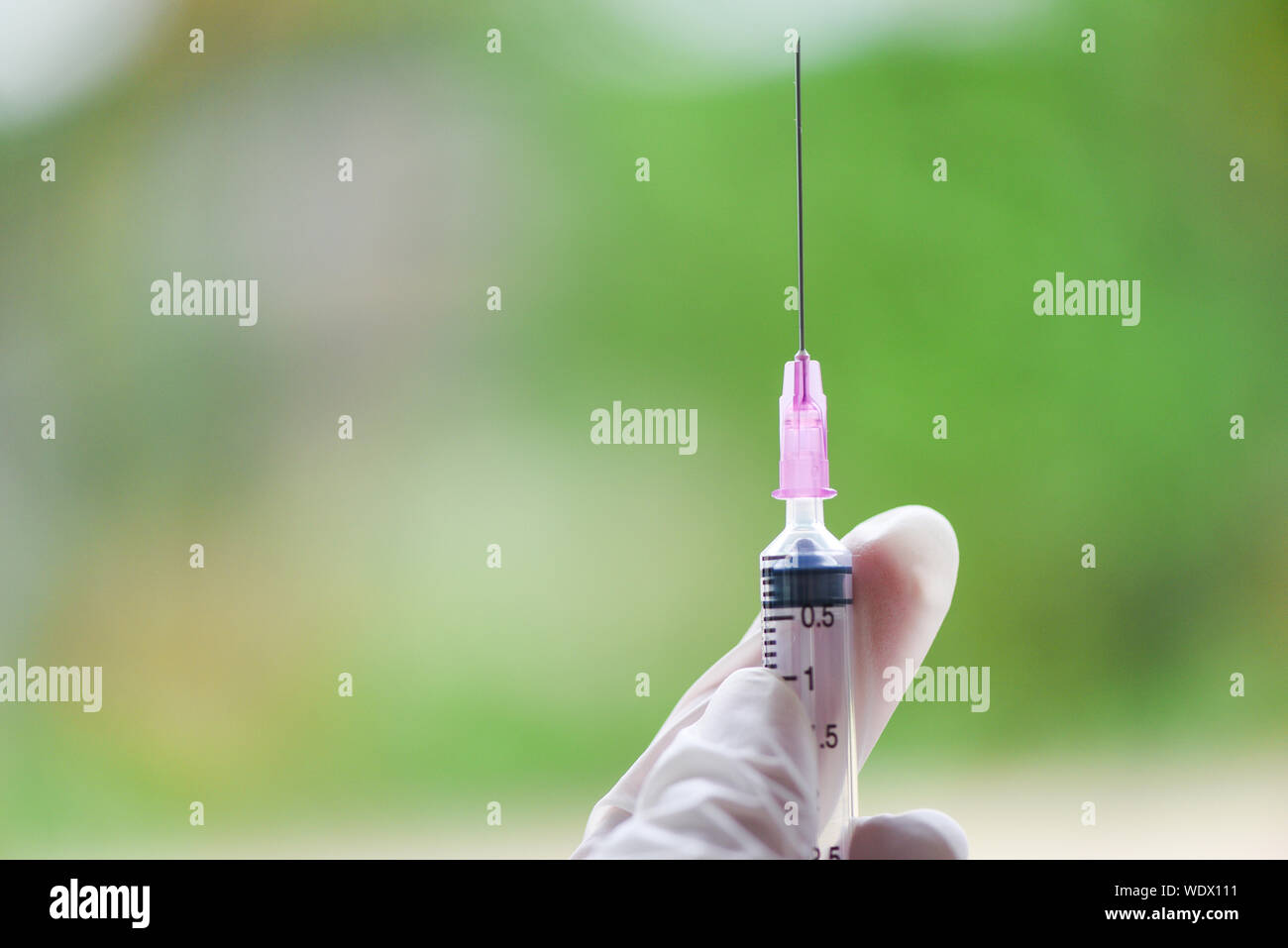 Siringa di iniezione di farmaco e l'ago in mano ad un infermiere per farsi dare paziente vaccino profilattico Foto Stock