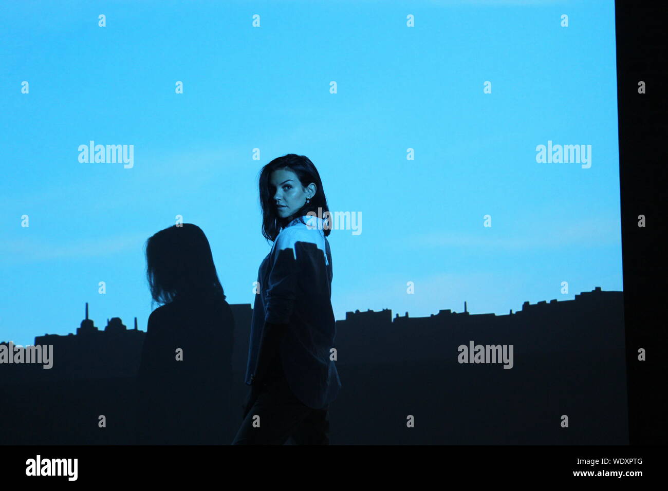 Ritratto di giovane donna in piedi contro lo schermo di proiezione Foto Stock