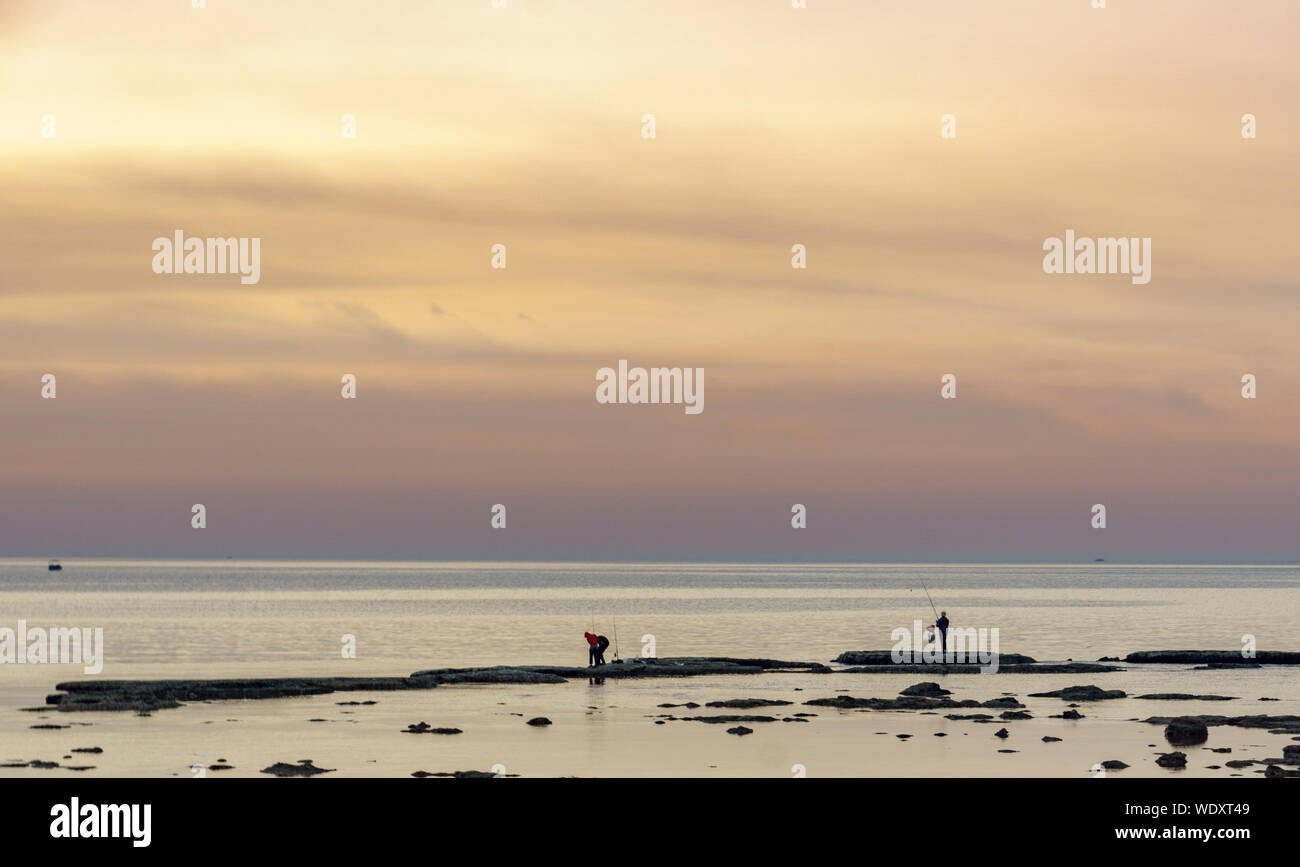 Un uomo pesca al tramonto a Tripoli in Libano 5 febbraio 2018 Foto Stock