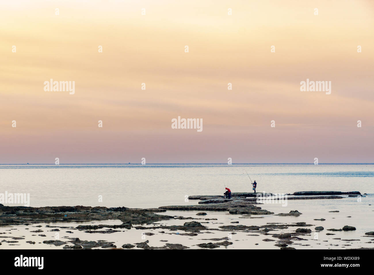 Un uomo pesca al tramonto a Tripoli in Libano 5 febbraio 2018 Foto Stock