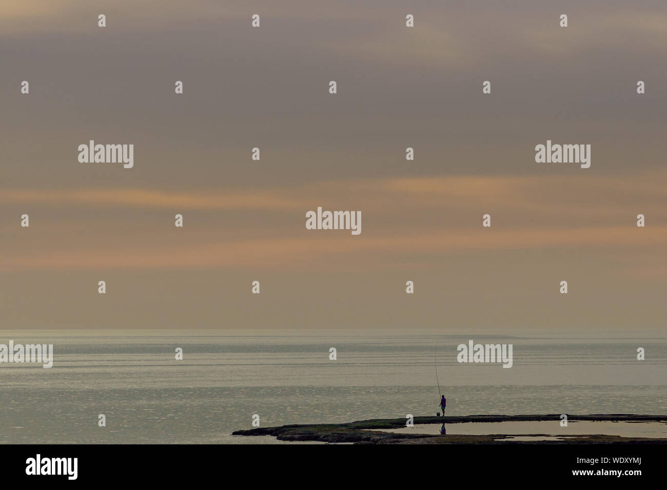 Un uomo pesca al tramonto a Tripoli in Libano 5 febbraio 2018 Foto Stock