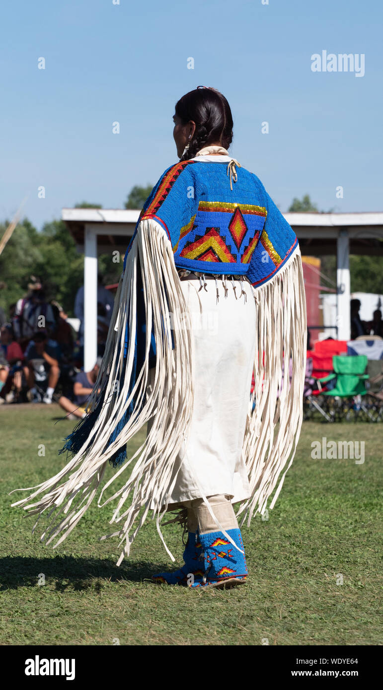 Native American woman dancing a Pow Wow con un abito di pelle con frange maniche e ornato beadwork. Fotografato da dietro. Foto Stock