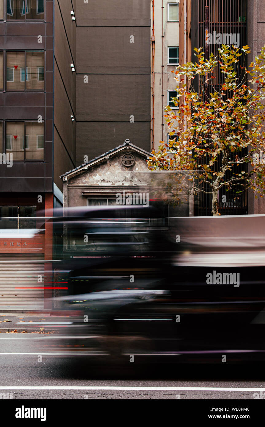 Dic 5, 2018 Tokyo, Giappone - in parte visibile della piccola vecchia casa giapponese tra gli edifici moderni in Kanda quartiere degli affari vicino al centro citta' di Tokyo con motio Foto Stock