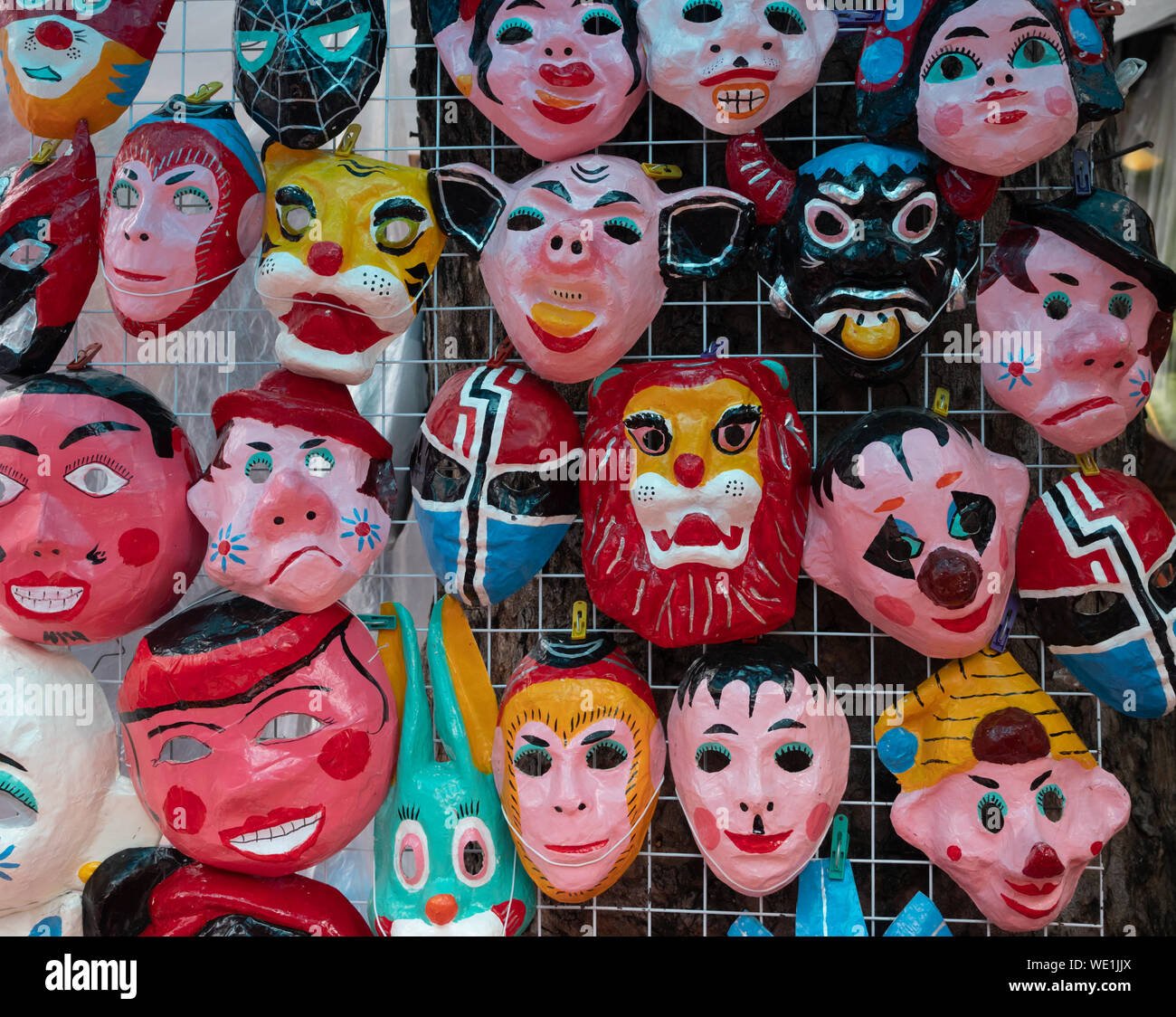 Storefront display dipinte a mano di maschere in cartapesta di molte varietà in vendita in Vietnam. Foto Stock