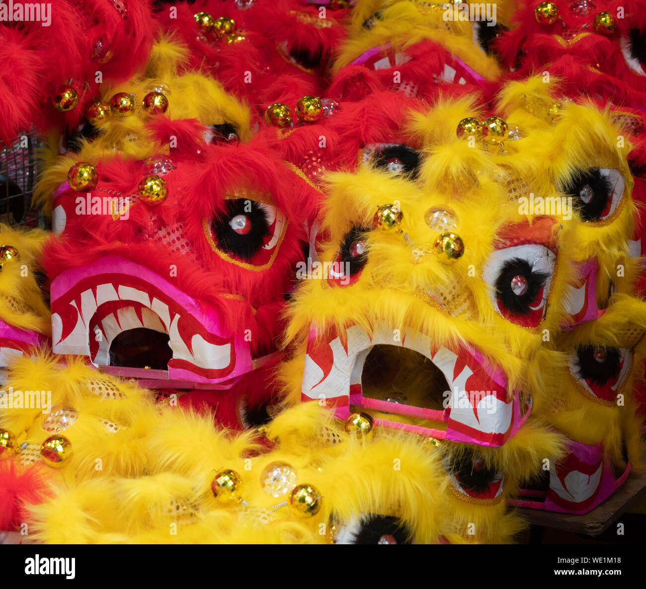 Il giallo e il rosso dragon maschere abbellita con ornamenti d'oro per la vendita in Vietnam. Foto Stock