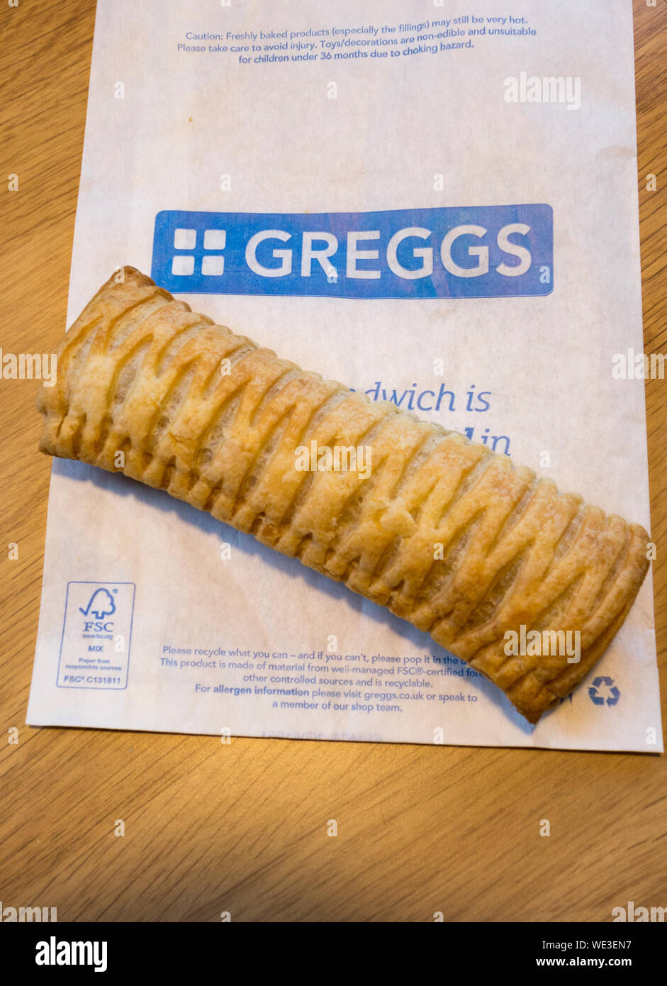 A Greggs, vegan-friendly, rotolo di salsiccia seduti sulla cima di alcune Greggs imballaggio Foto Stock