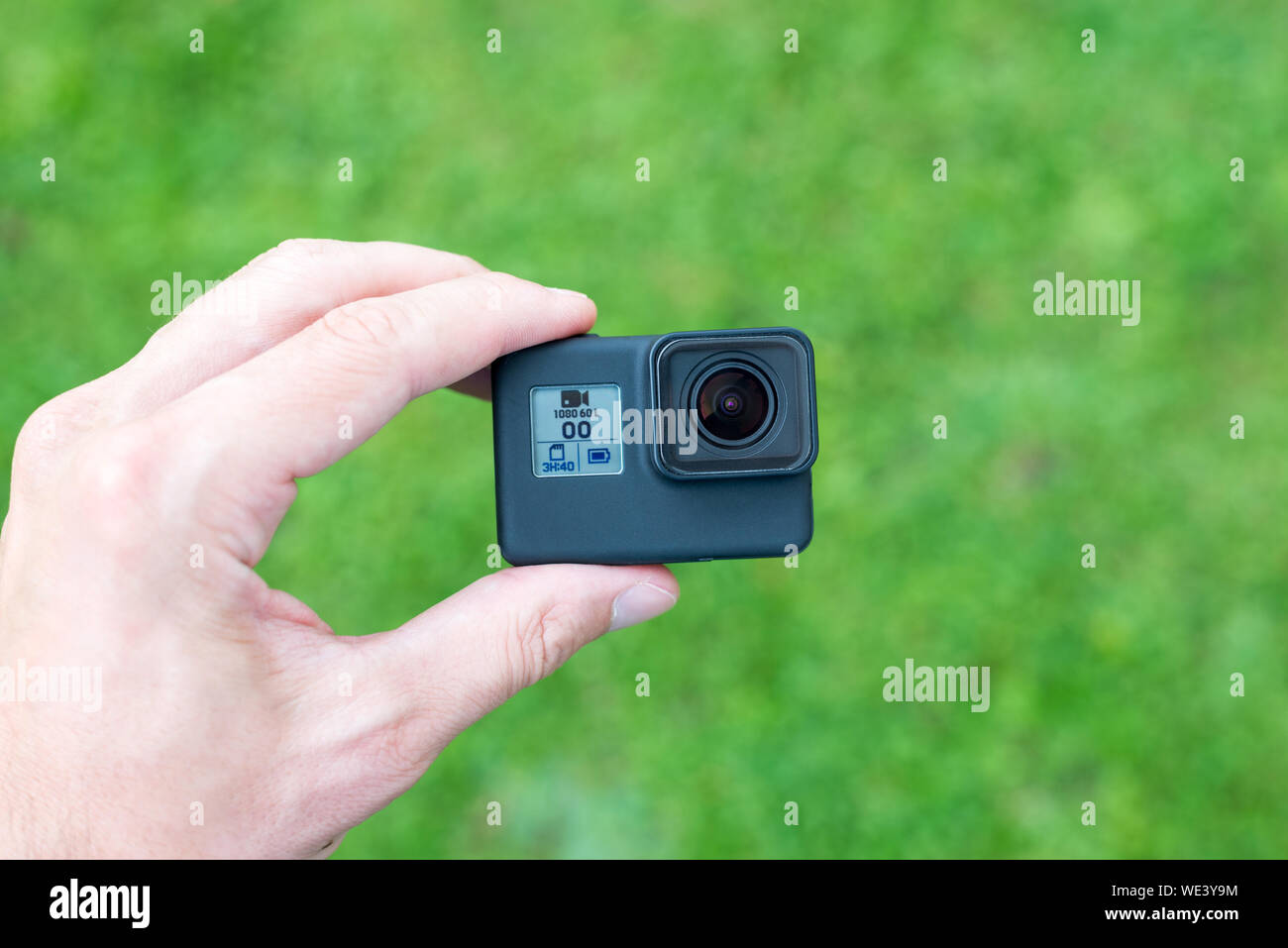 Azione macchina fotografica in mano di close-up. Lente e piccolo display con risoluzione, batteria e le informazioni sulla scheda di memoria. Foto Stock