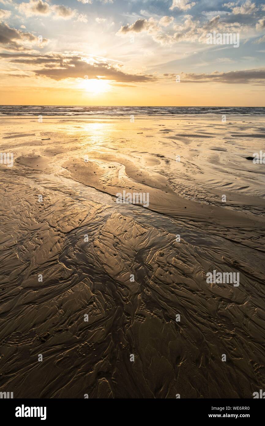 Francia, Somme, Ault, i meandri di acqua che scorre sulla spiaggia di Ault a bassa marea al tramonto Foto Stock