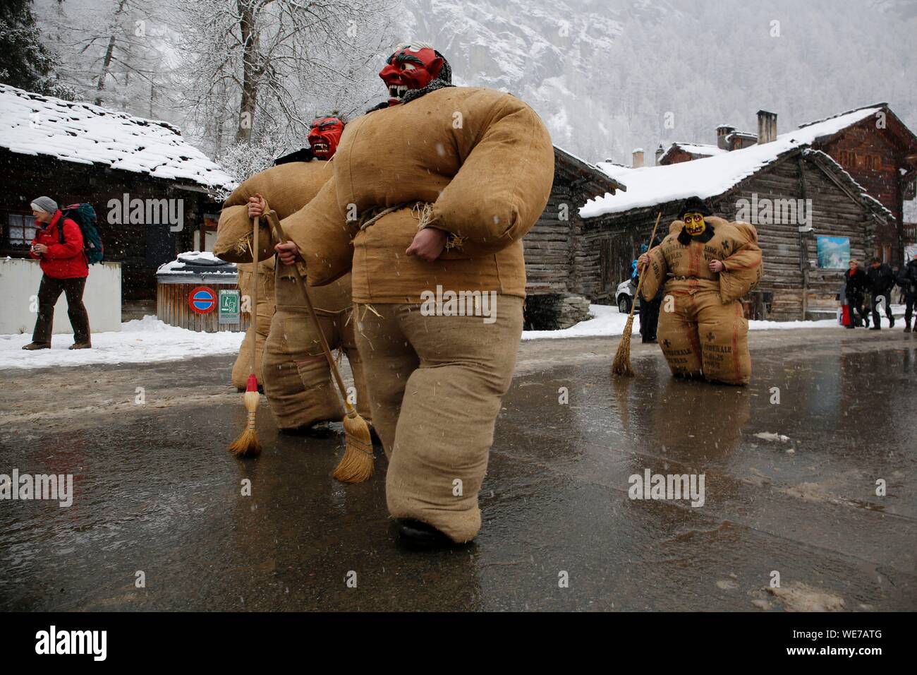 La Svizzera e il Cantone del Vallese, Val d'Herens, villaggio di Evolene, Carnaval, preparazione del empailles ( giovani uomini vestiti con vecchi sacchetti ripieni di circa 50 kg di paglia) e indossando un localmente in legno intagliato che rappresenta la maschera mitico e spesso afraying animali Foto Stock