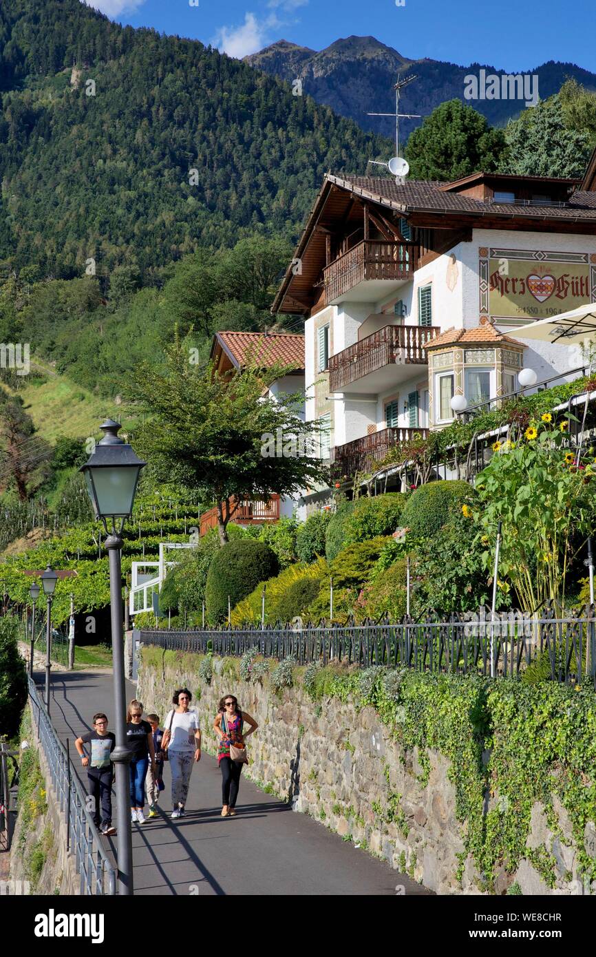L'Italia, provincia autonoma di Bolzano, Tirol, famiglia passeggiate a piedi di uno chalet in Tirolo, il paese che ha dato il suo nome alla regione del Tirolo Foto Stock