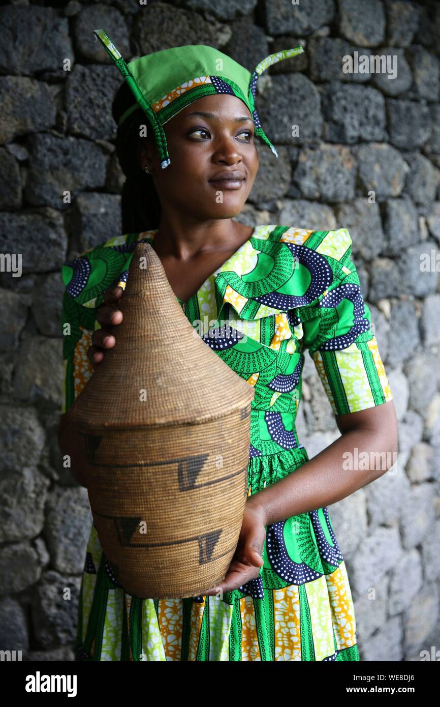 Ruanda, Parco Nazionale Vulcani, giovane donna ruandese in abito tradizionale, membro dello staff di Bisate Lodge, portante un basketry Foto Stock
