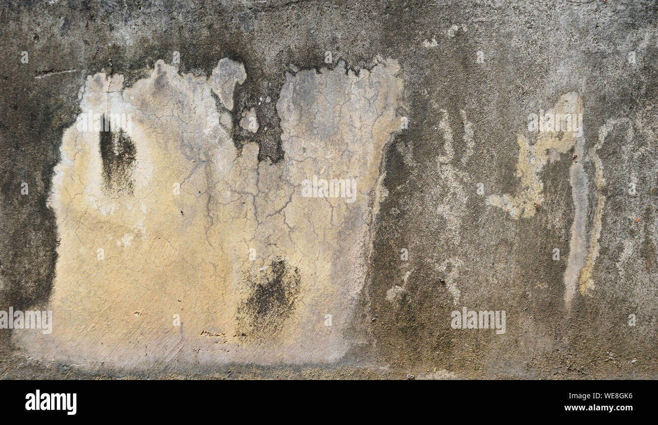 Macchie e crepe sulla superficie di calcestruzzo , nero e marrone a strisce su sfondo grigio Foto Stock