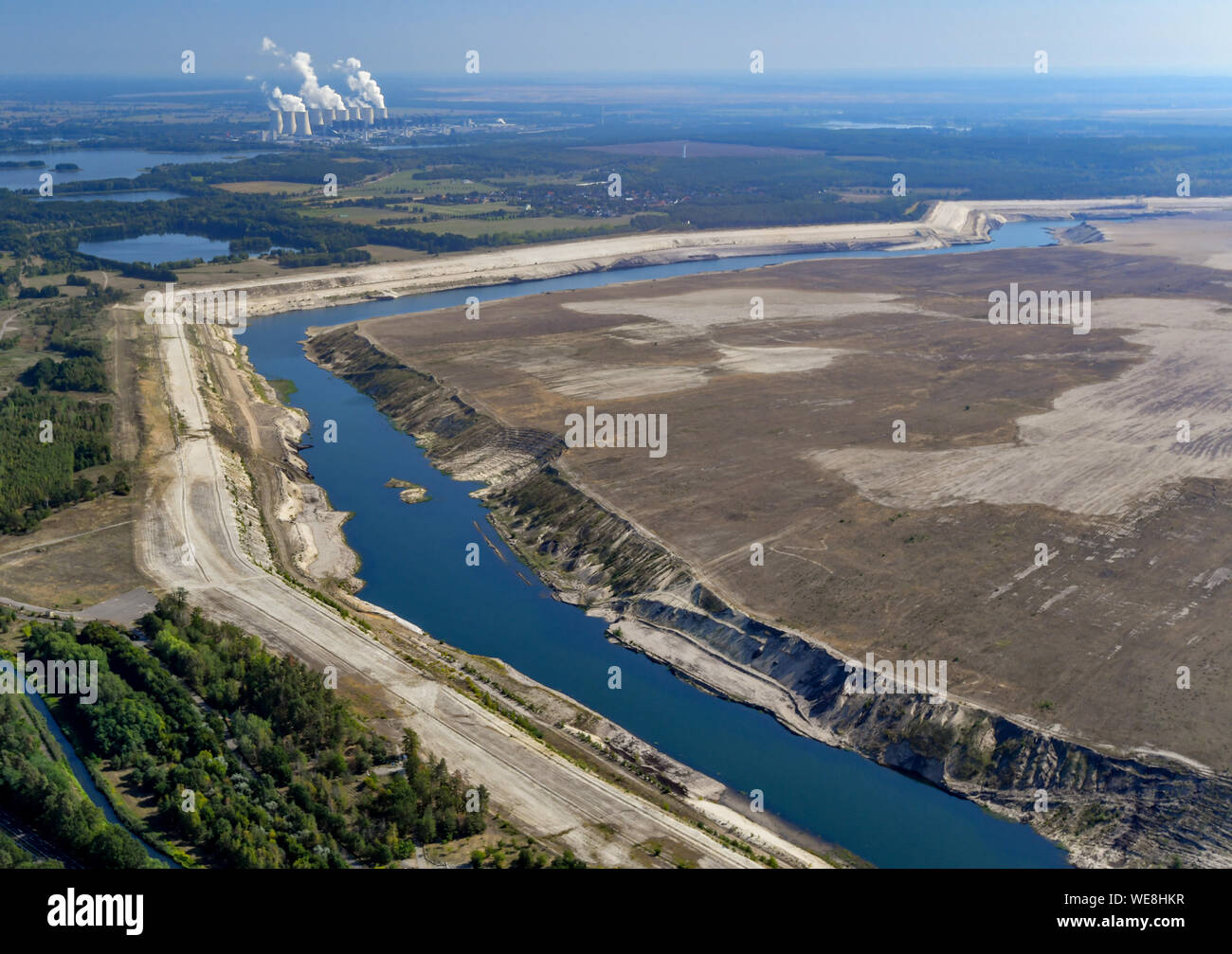 Cottbus, Germania. 23 Ago, 2019. L'ex fossa aperta miniera di lignite Cottbus-Nord (vista aerea da un aeroplano). Sullo sfondo il vapore delle torri di raffreddamento di Jänschwalde alimentato a lignite power plant di Lausitz Energie Bergbau AG (LEAG) può essere visto. L'enorme zona sabbiosa sarà il futuro Cottbus del Mar Baltico. Le inondazioni dell'ex Cottbus-Nord miniera a cielo aperto ha cominciato a metà aprile 2019. Il lago artificiale sarà più tardi hanno una superficie d'acqua di 19 chilometri quadrati. Credito: Patrick Pleul/dpa-Zentralbild/ZB/dpa/Alamy Live News Foto Stock