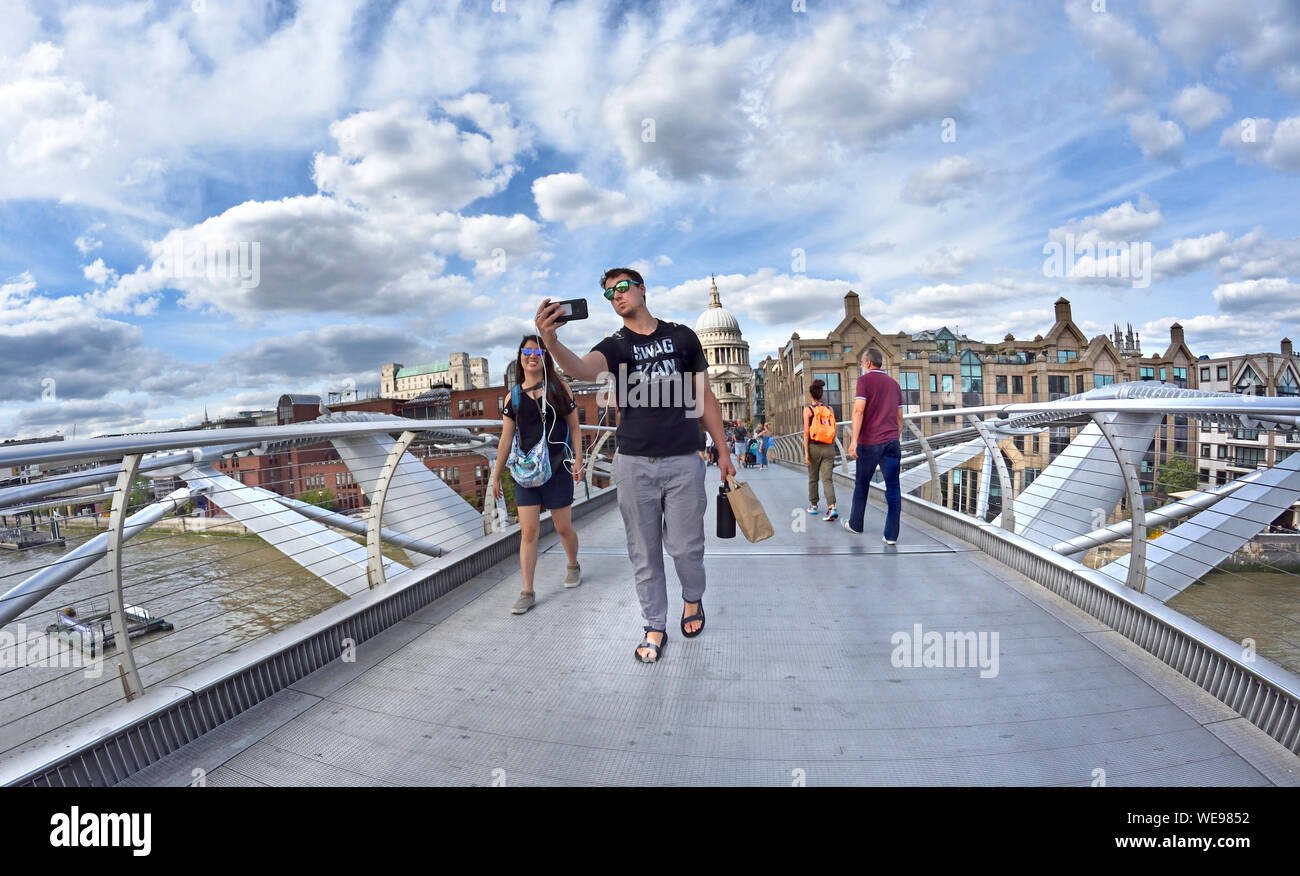 Londra, Inghilterra, Regno Unito. Le persone che attraversano il Millennium Bridge in una giornata di sole nel mese di agosto Foto Stock