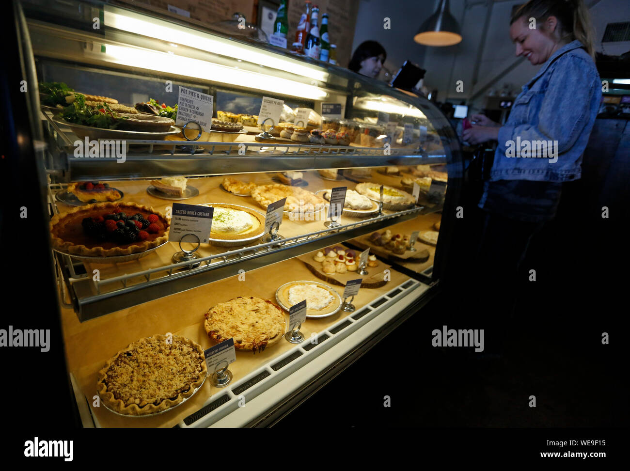 (190830) -- LOS ANGELES, il 30 agosto 2019 (Xinhua) -- una donna torte di acquisti in un negozio di torta a Los Angeles, negli Stati Uniti il 29 agosto 2019. Un grafico a torta è un piatto cotto al forno che è generalmente costituito da un impasto involucro che copre completamente o contiene un riempimento dei vari ingredienti. "Pie' ha tessuto il suo modo in American food culture, diventando un simbolo di casa, tradizione e abbondanza. Una famosa frase dice, 'Come American come la torta di mele.' (Xinhua/Li Ying) Foto Stock