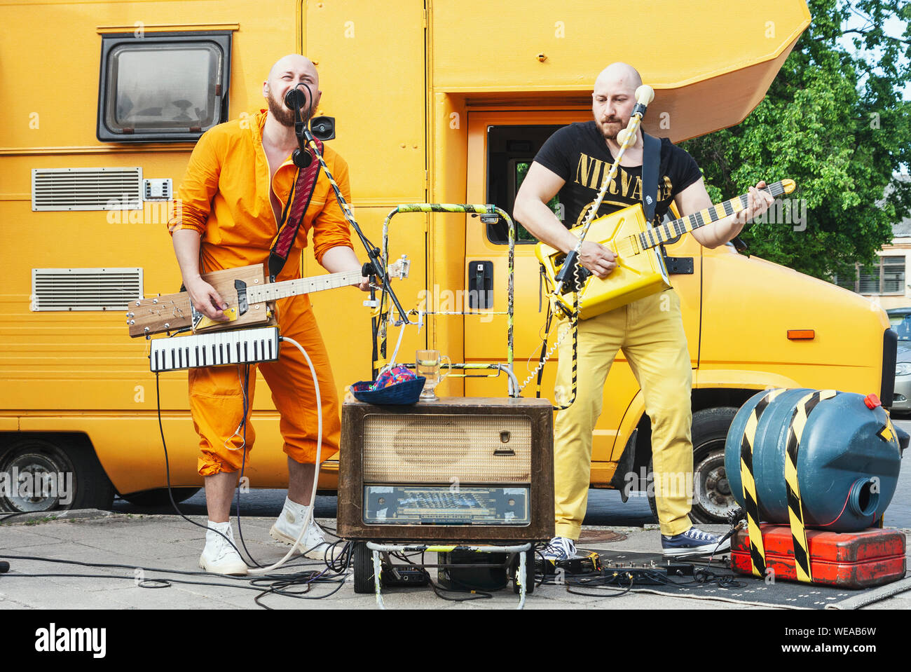 Due eccentrico uomo rock band con fatti a mano gli strumenti musicali eseguendo sulla strada al tradizionale musica di strada Foto Stock
