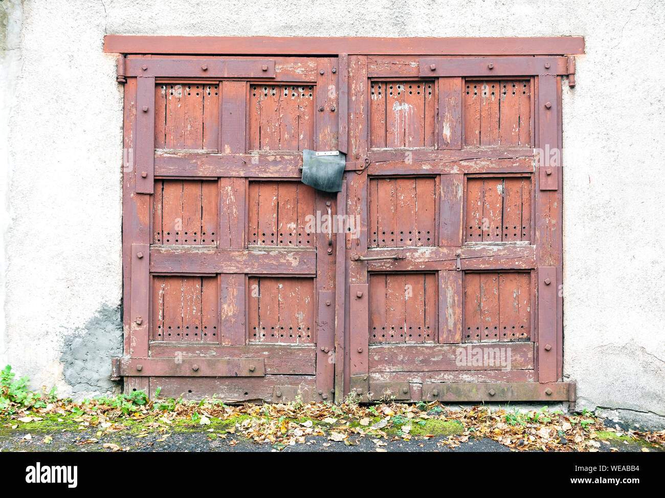 Vecchio abbandonato garage in legno porte, chiusura porte spiovente vista frontale Foto Stock