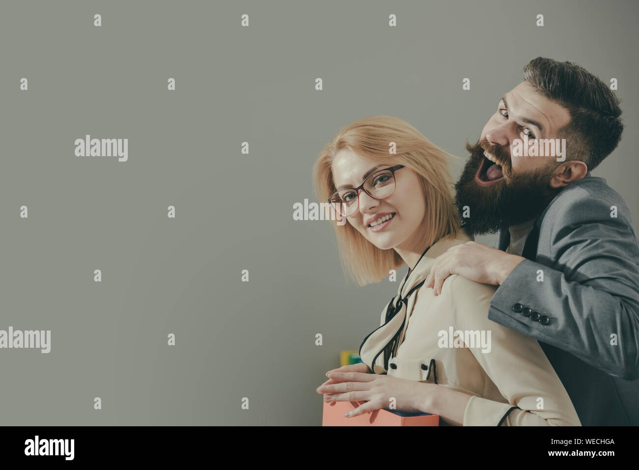 Uomo di toccare collega femmina sulla spalla in modo improprio in ufficio, copia dello spazio. Foto Stock