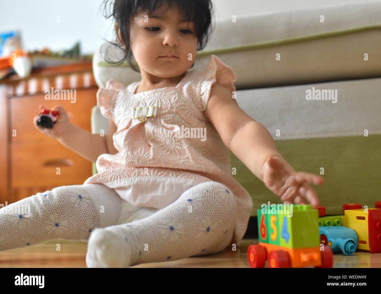 Carino bambina gioca con i giocattoli in vivaio Foto Stock