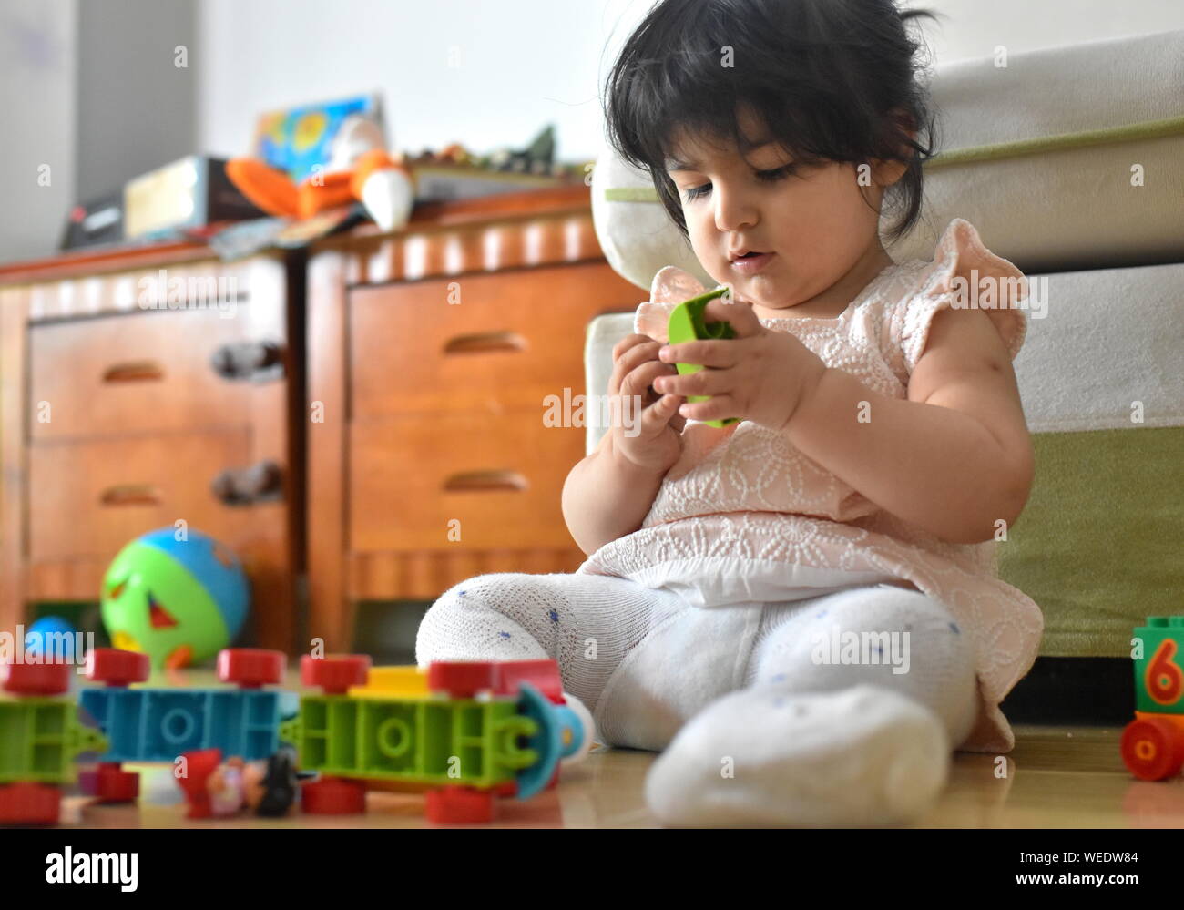 Carino bambina gioca con i giocattoli di apprendimento in vivaio Foto Stock