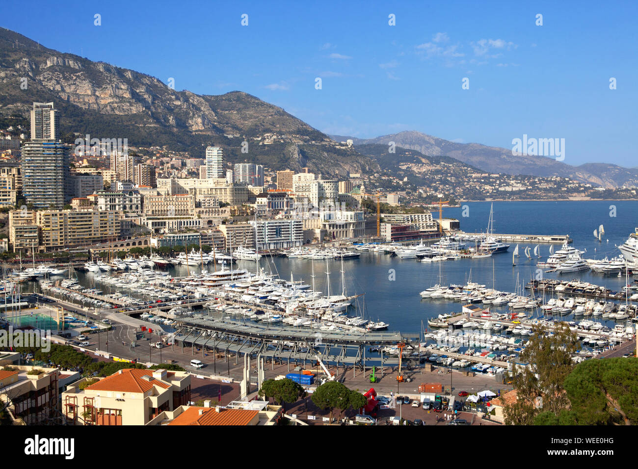 Le navi nella baia di Monaco su uno sfondo blu. Case di città sullo sfondo. Foto Stock