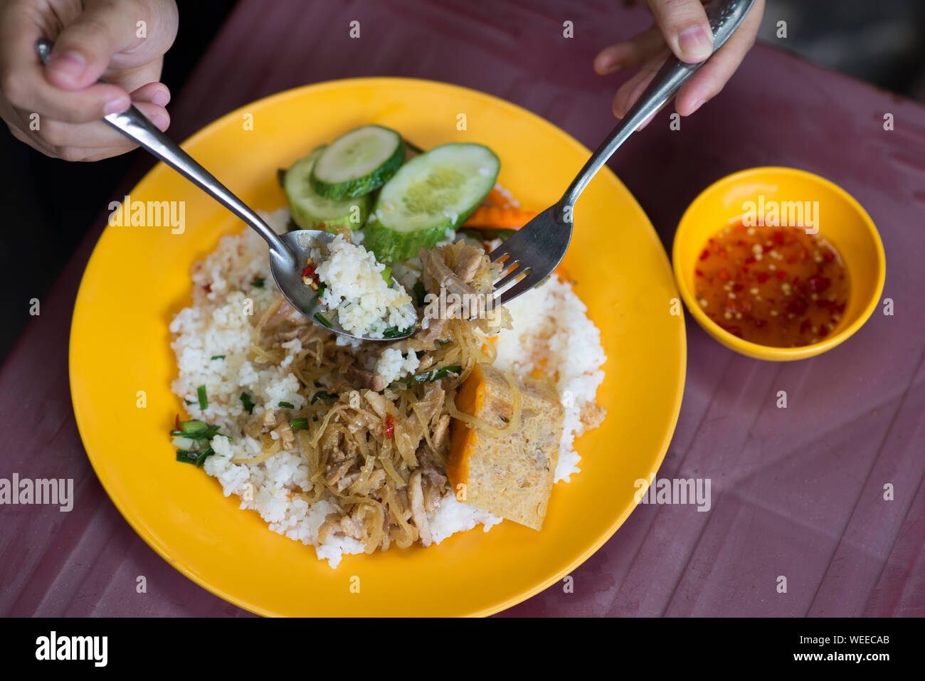 Persone mangiare deliziosa vietnamita di rotture di riso com tam Foto Stock